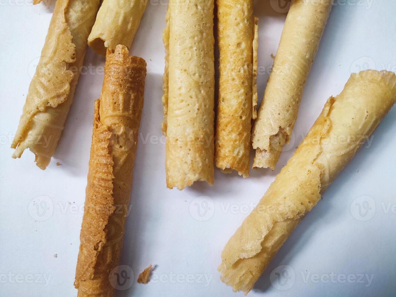 Kue semprong or Asian egg roll. This is a traditional Indonesian wafer or kuih snack isolated on a white background photo