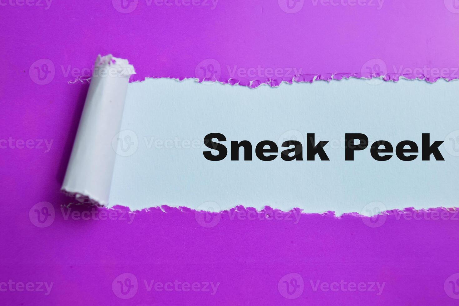 Concept of Sneak Peek Text written in torn paper. photo