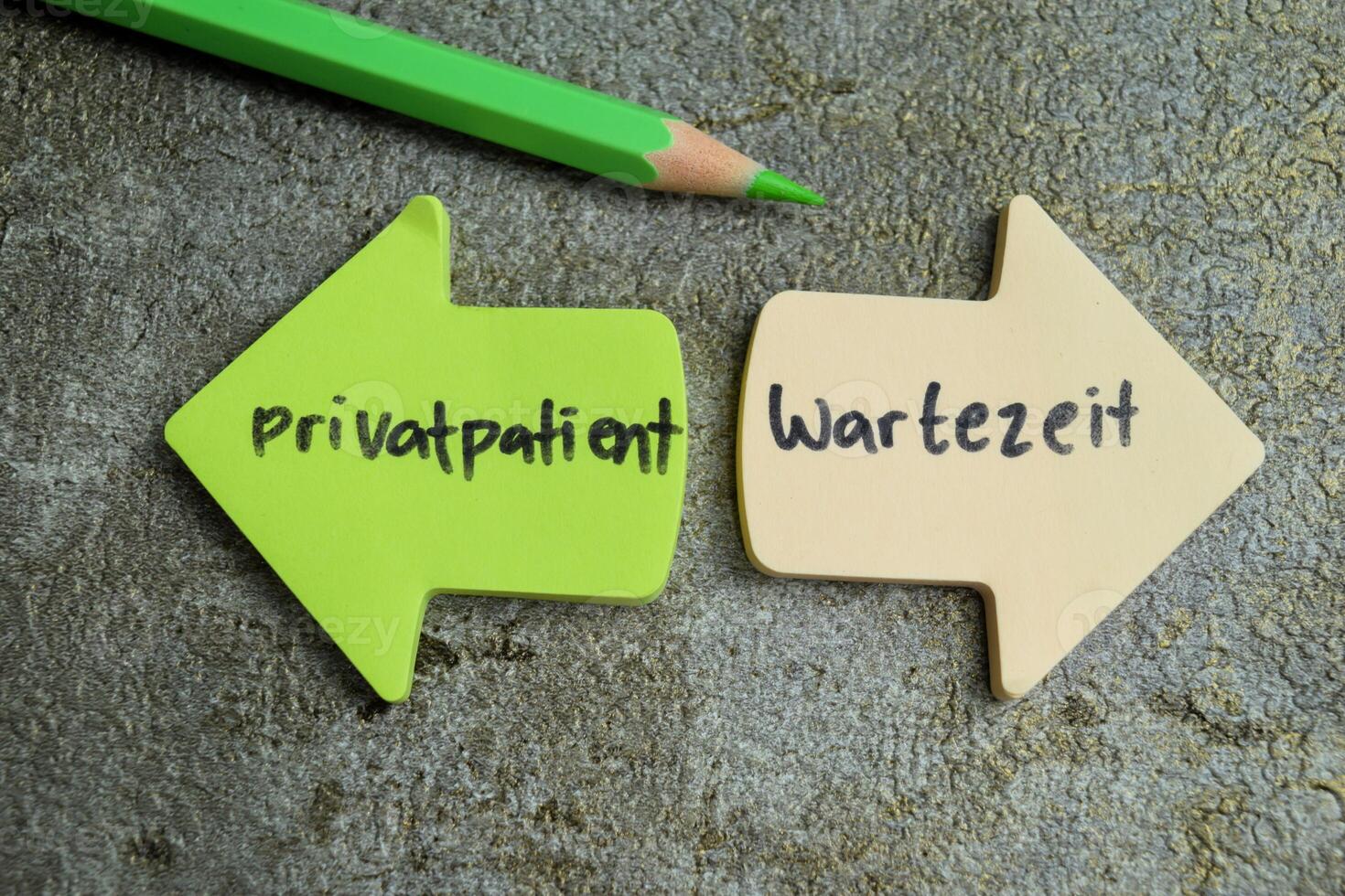 Concept of Learning language - German. Privatpatient - Wartezeit it means Private patient and waiting time written on sticky notes. German language isolated on Wooden Table. photo