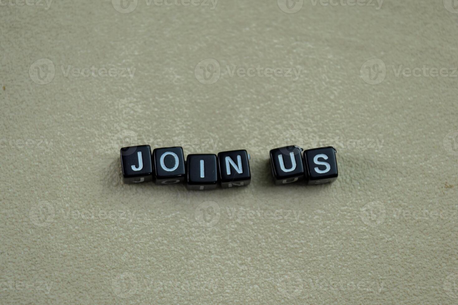 Concept of Join Us written on wooden blocks. Cross processed image on Wooden Background photo