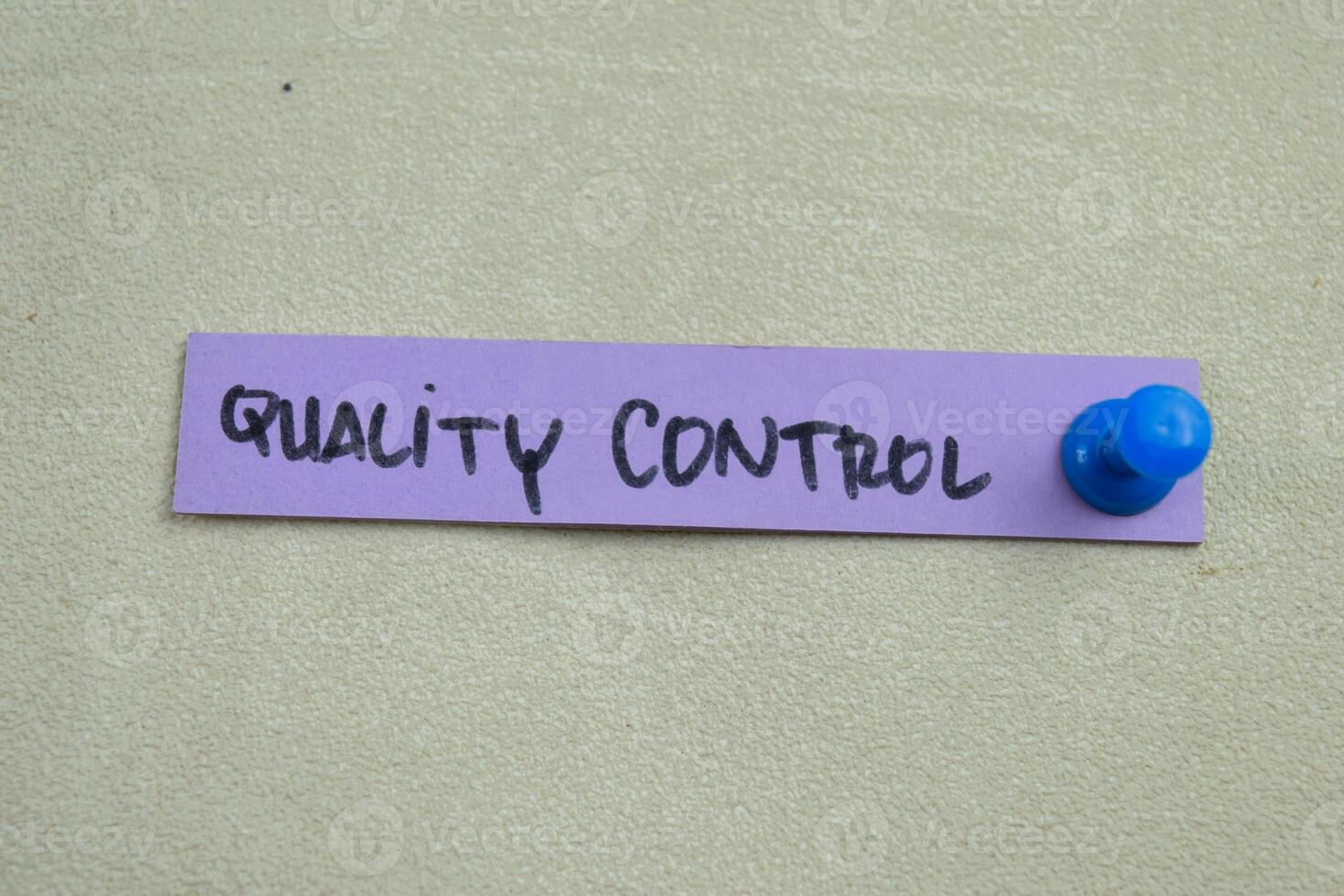 Concept of Quality Control write on sticky notes isolated on Wooden Table. photo
