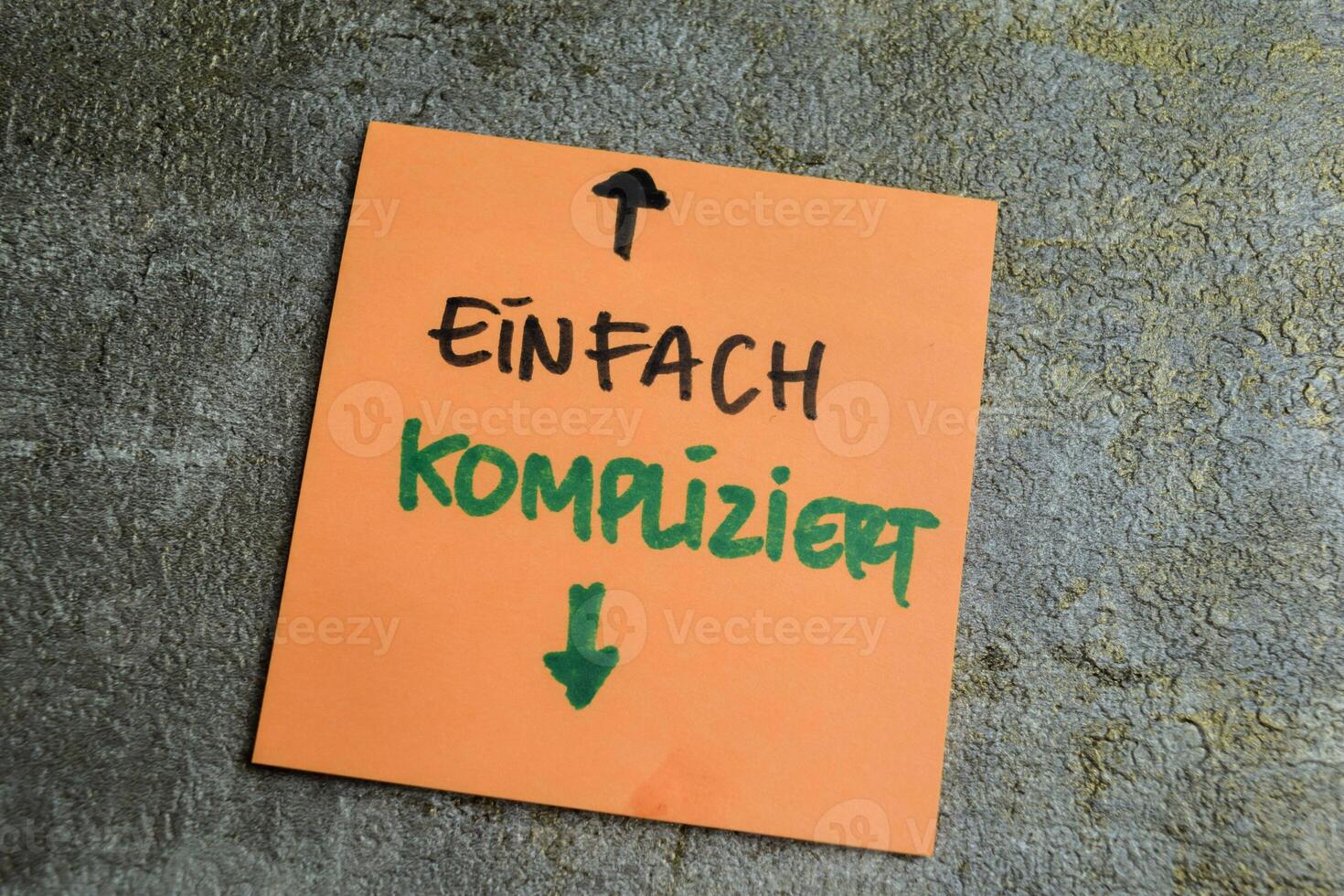 Concept of Learning language - German. Einfach Kompliziert it means Simply complicated written on sticky notes. German language isolated on Wooden Table. photo