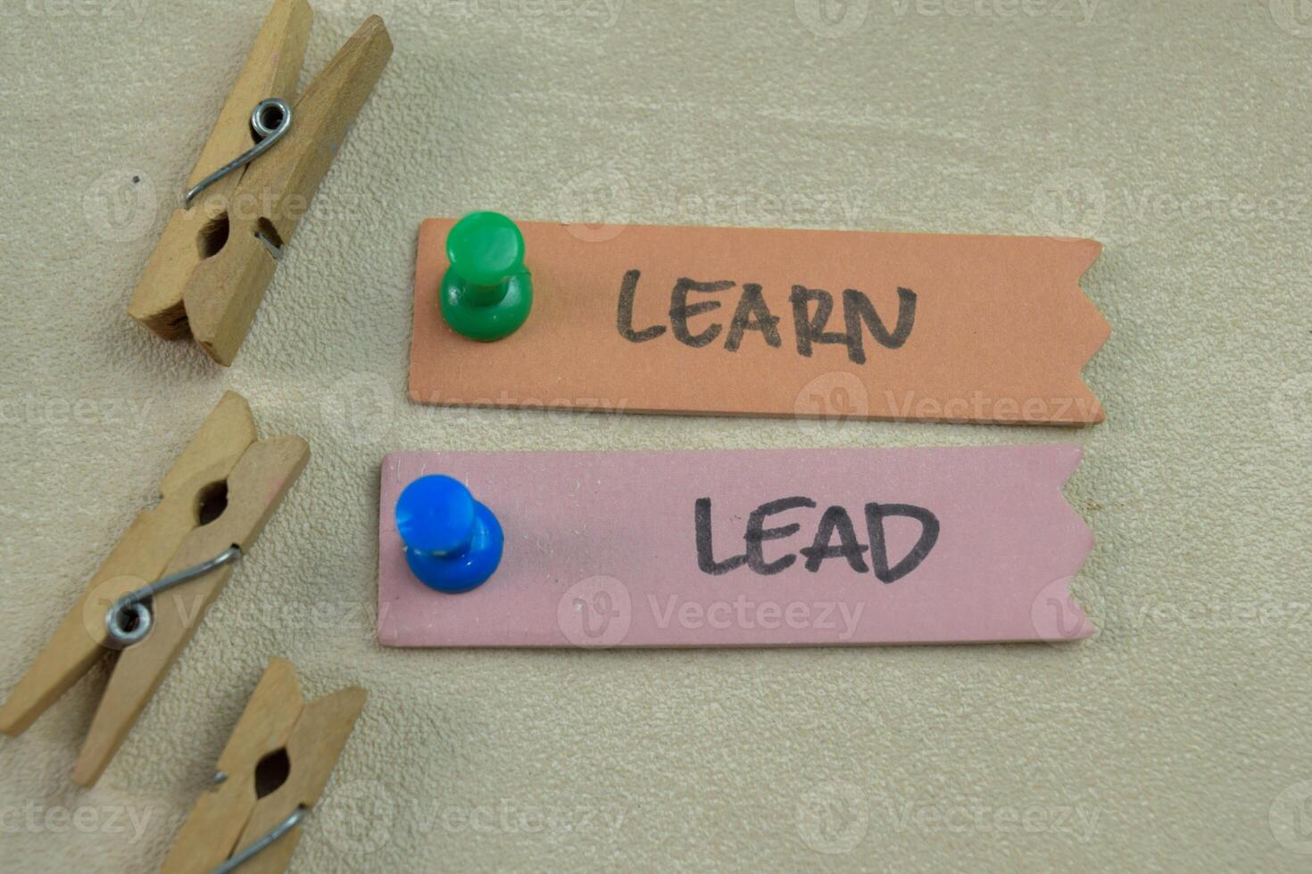 Concept of Learn and Lead write on sticky notes isolated on Wooden Table. photo