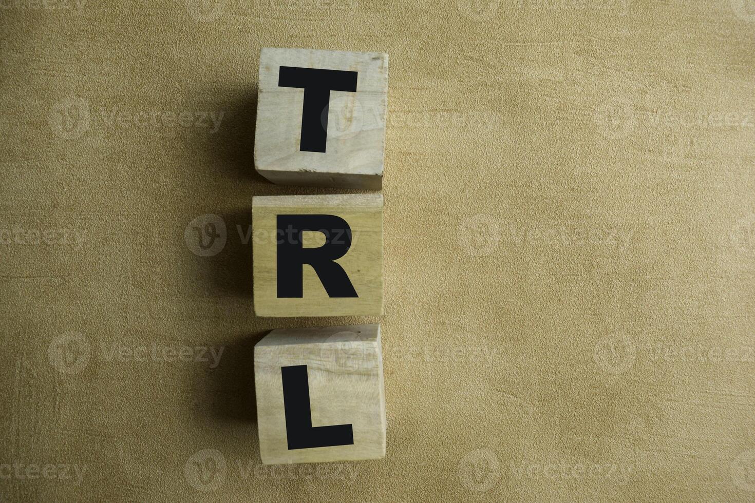 Concept of The wooden Cubes with the word TRL - Technology Readiness Level on wooden background. photo