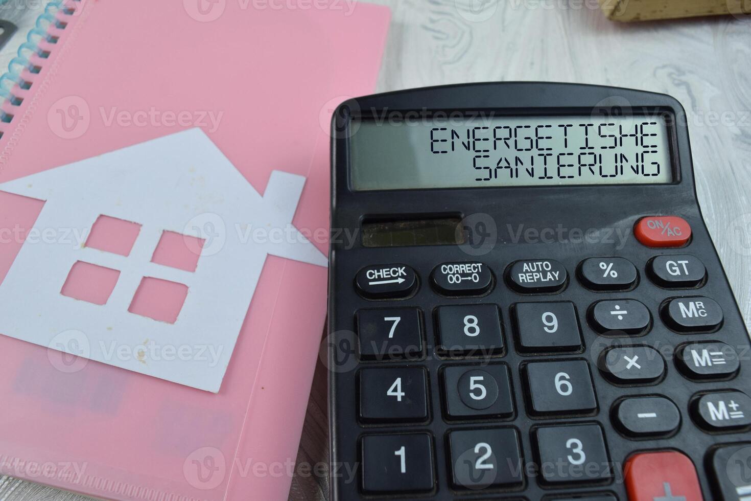 Energetishe Sanierung write on the calculator with wooden background. photo