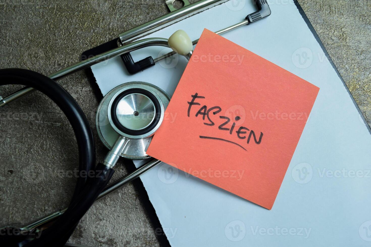 Concept of Learning language - German. Faszien it means Fascia written on sticky notes. German language isolated on Wooden Table. photo