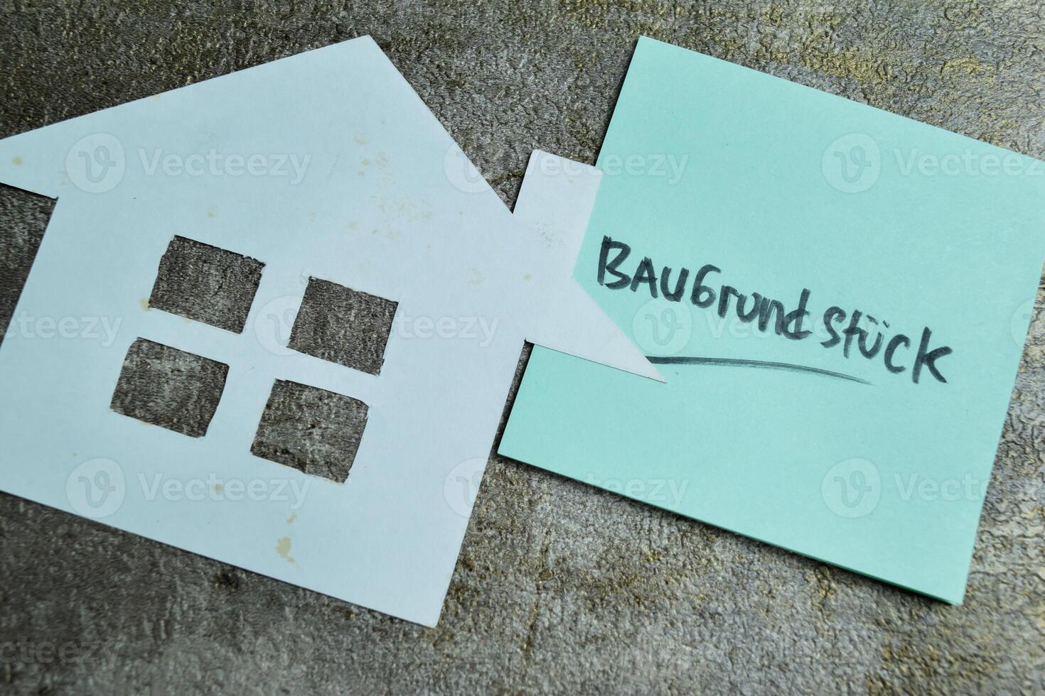 Concept of Learning language - German. Baugrundstuck it means Building ground written on sticky notes. German language isolated on Wooden Table. photo