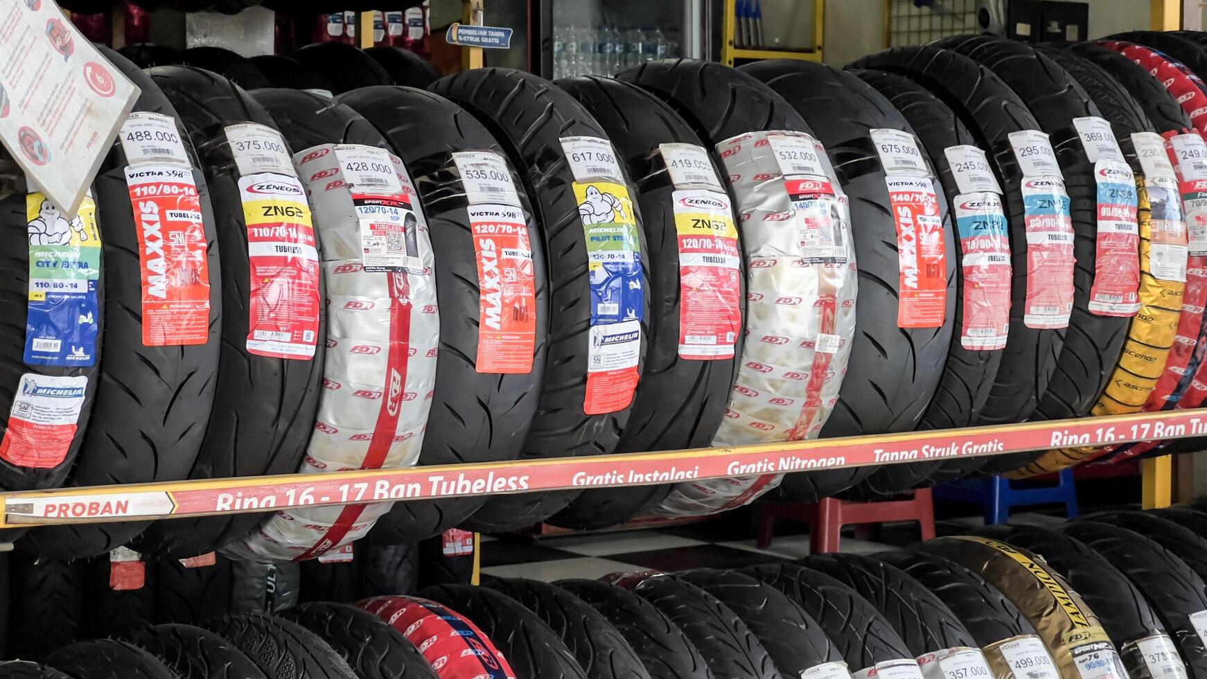 Car tires on rack in auto store, motorcycle transport concept. Bekasi, Indonesia, May 1, 2024 photo