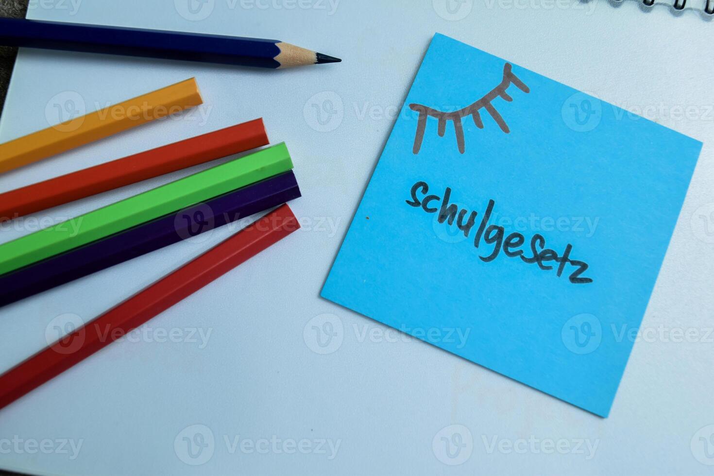 Concept of Learning language - German. Schulgesetz it means School law written on sticky notes. German language isolated on Wooden Table. photo