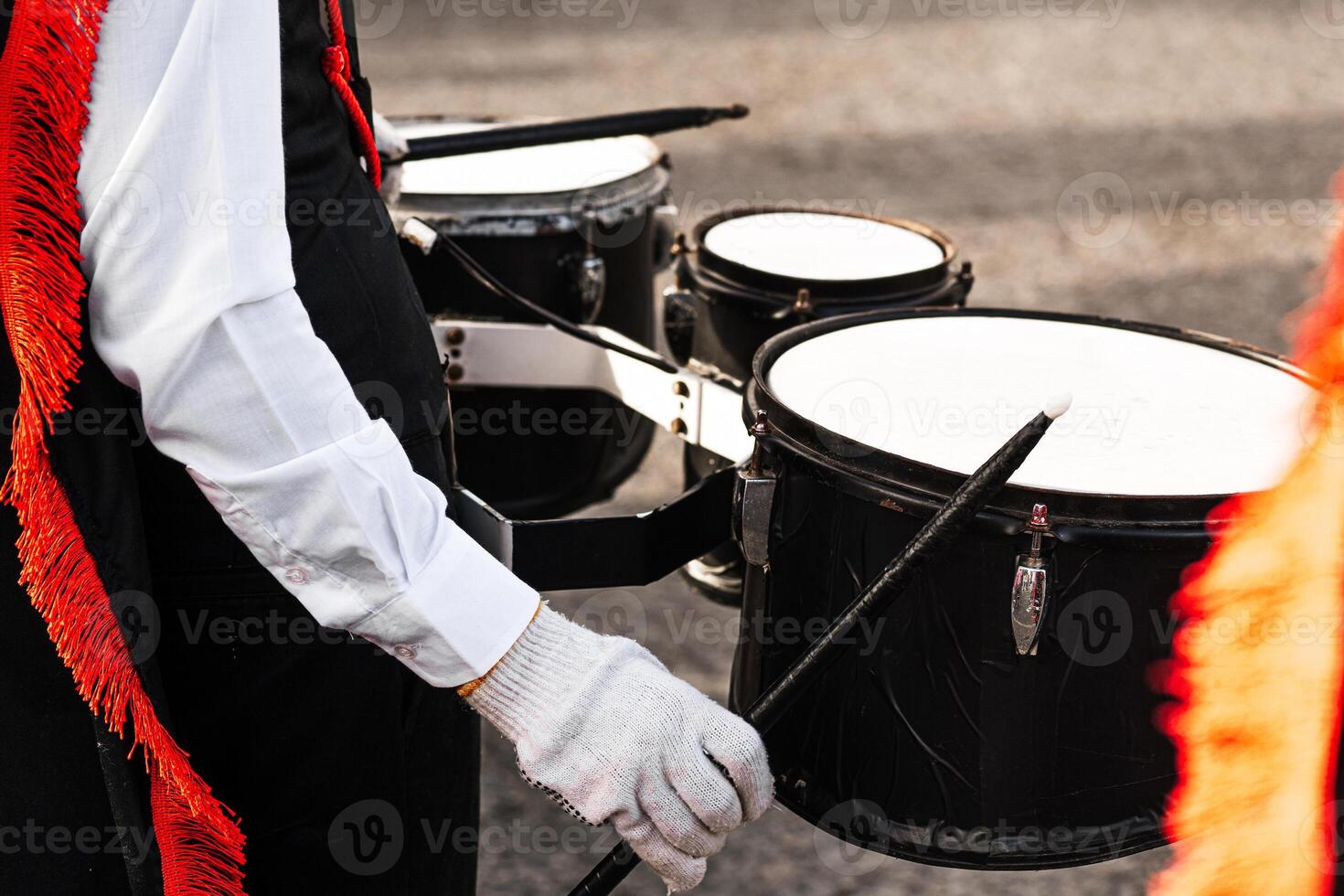Hands of a person holding drumsticks playing in a marching band. photo
