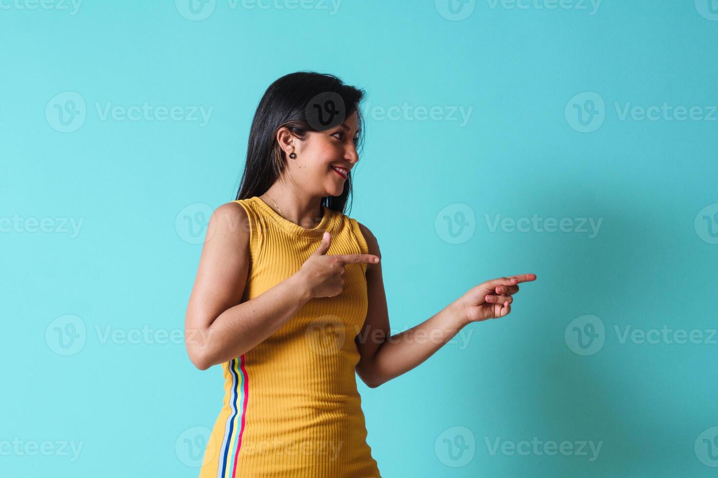 Young happy latinx woman pointing with hands and fingers up to the side. photo