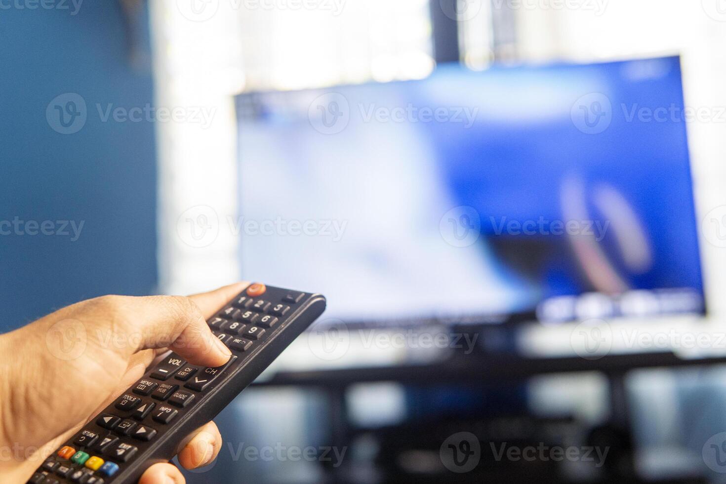 Hands holding a remote control changing channels. TV industry Concept. photo