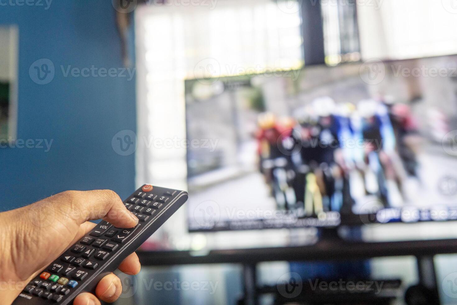 Hands holding a remote control watching a tv photo