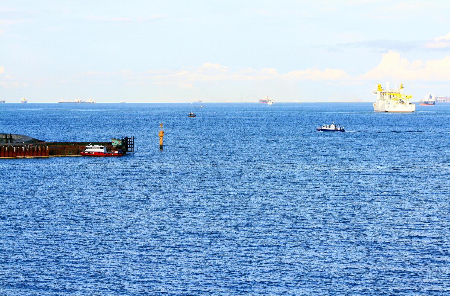 Harbor and boat are carrying cargo on the sea in Singapore. Transportation and Beautiful landscape view of ocean with clear blue sky and cloud background. photo
