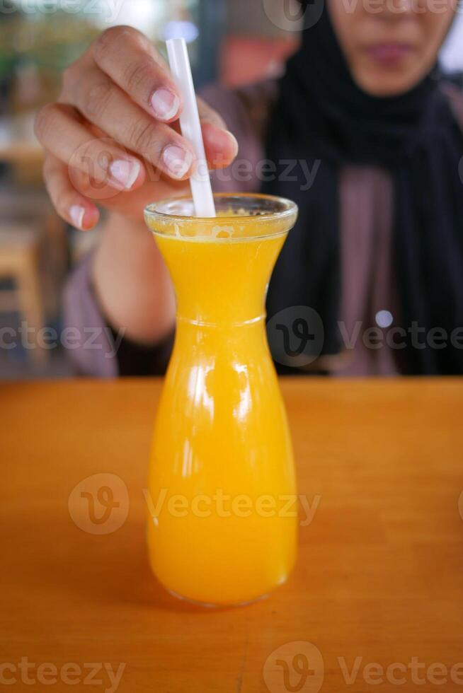 women hand holding a glass of orange juice photo