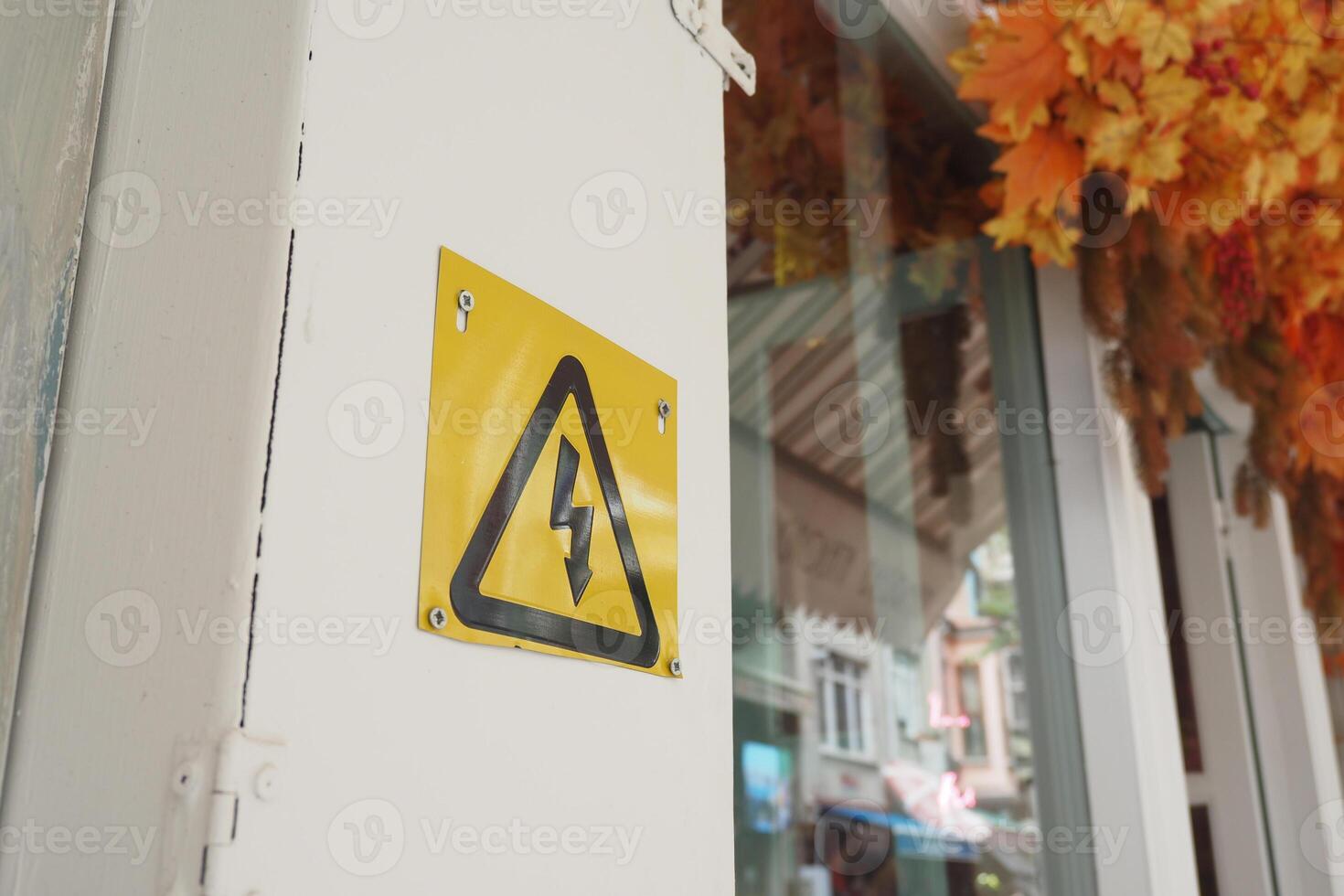 Two electrical boxes with lightning bolt on brick wall photo