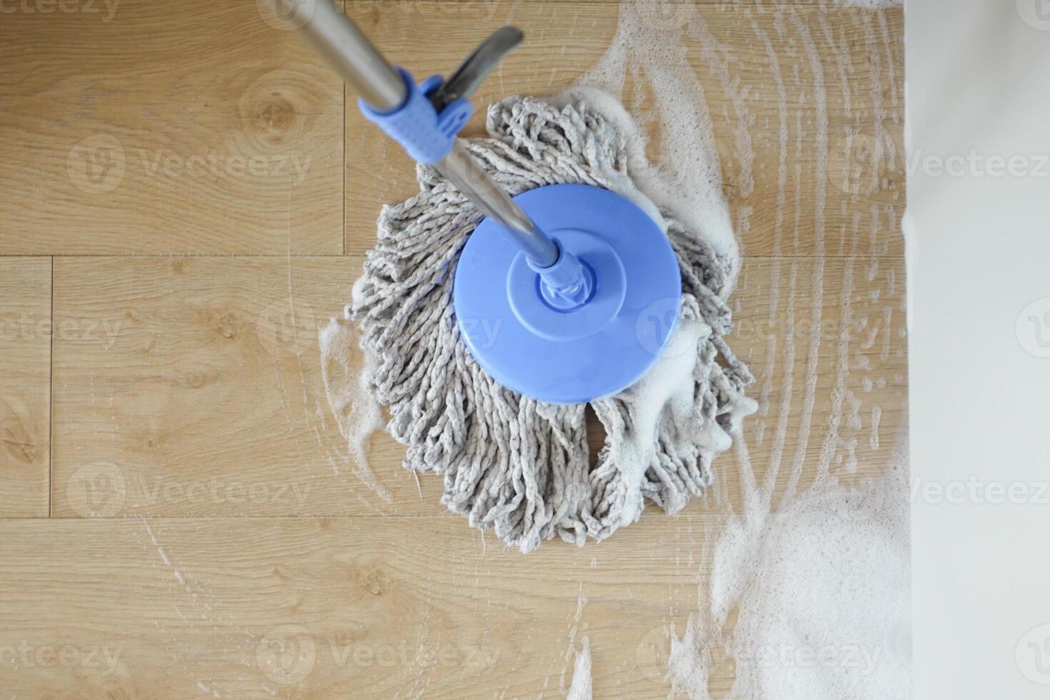 cleaning tiles floor with mop photo