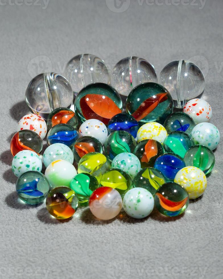 a collection of various types and sizes of marbles grouped together photo