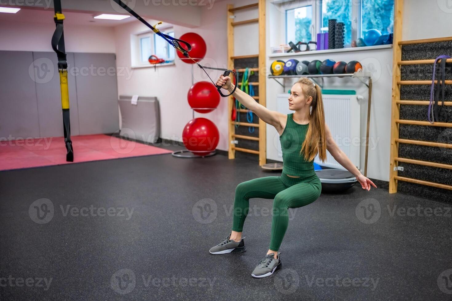 Training in the gym for the figure correction. Young woman doing fitness exercises at gym. High quality photo