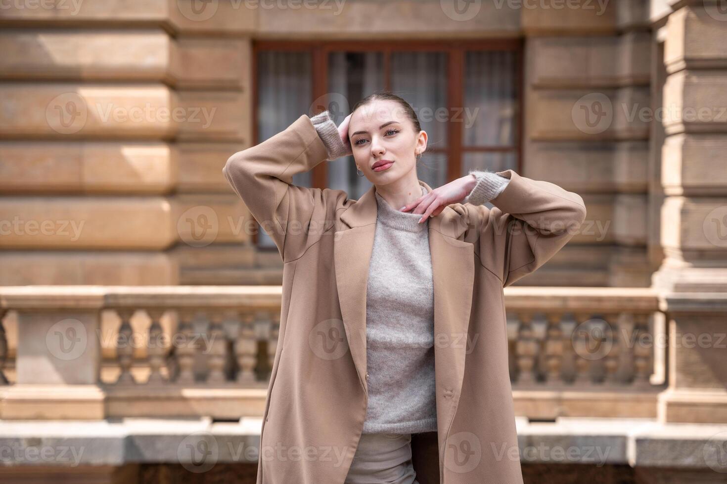 Portrait of young beautiful woman wearing coat walking in the city centre of Prague, Europe. High quality photo