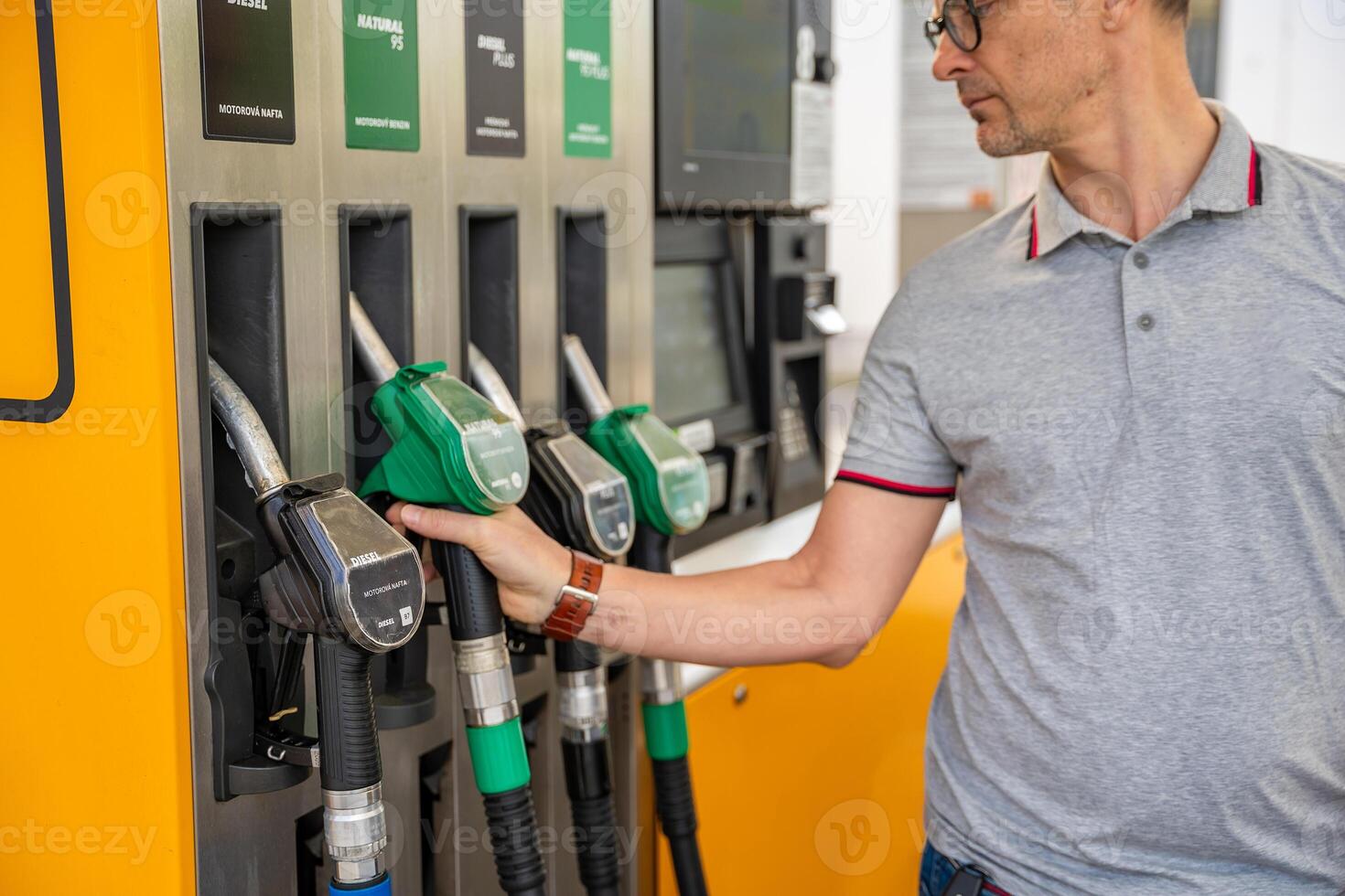 Man holding a gasoline nozzle in his hand on self-service filling station, but focus on cheaper diesel in Europe. High quality photo
