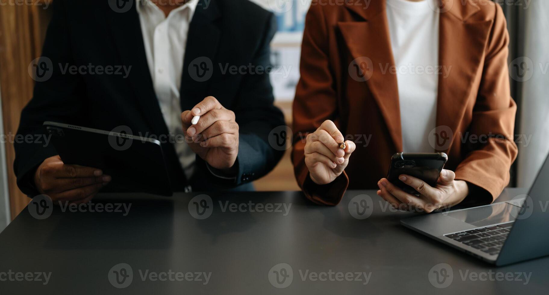 Business documents on office table with smart phone and calculator digital tablet and graph business with social network diagram and two colleagues discussing data photo