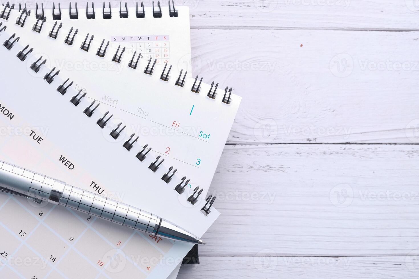stack of calendar and pen on office desk photo