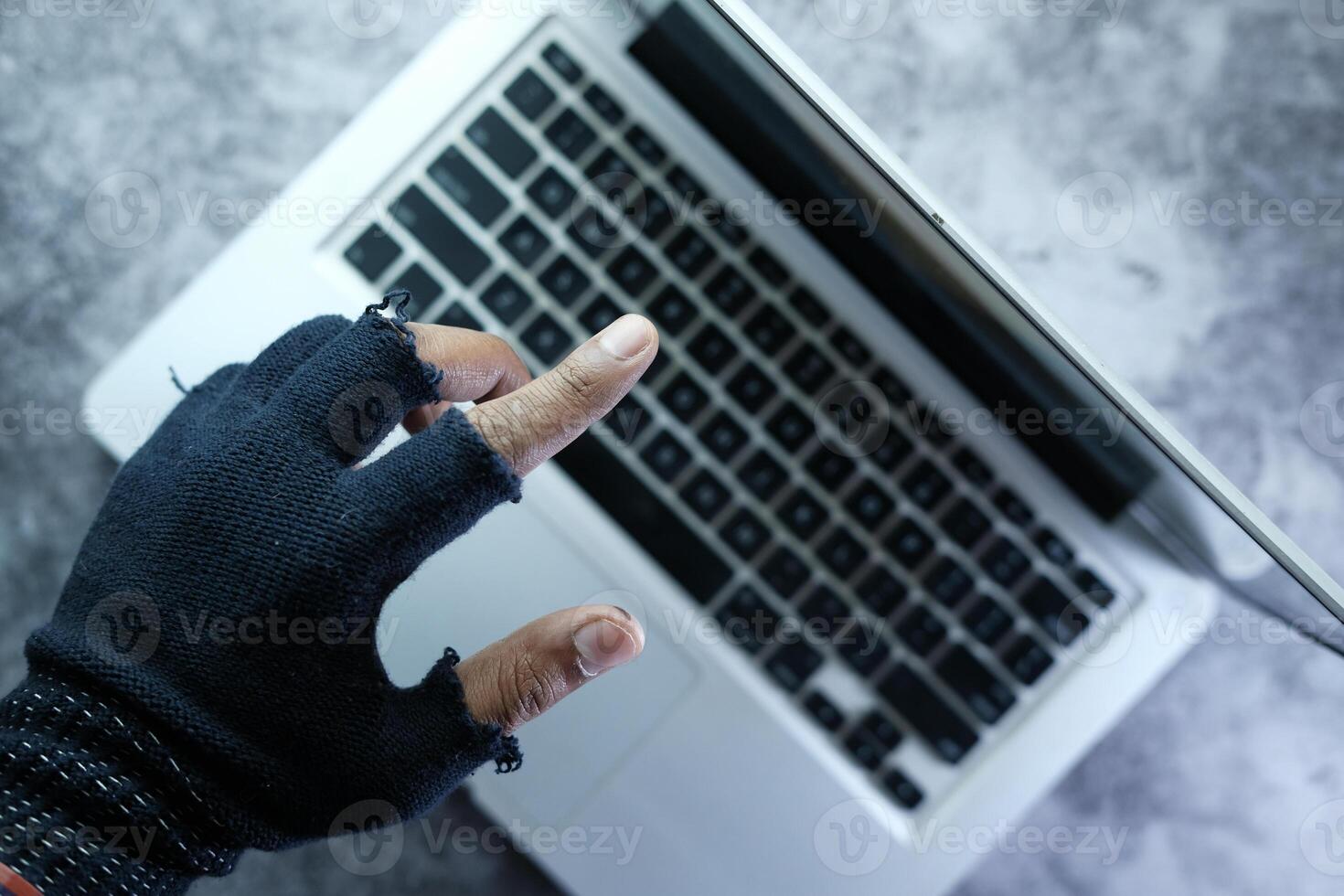 hacker hand stealing data from laptop at night photo