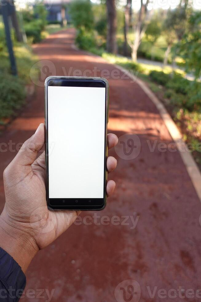 pov Disparo de joven hombre utilizando inteligente teléfono a al aire libre foto