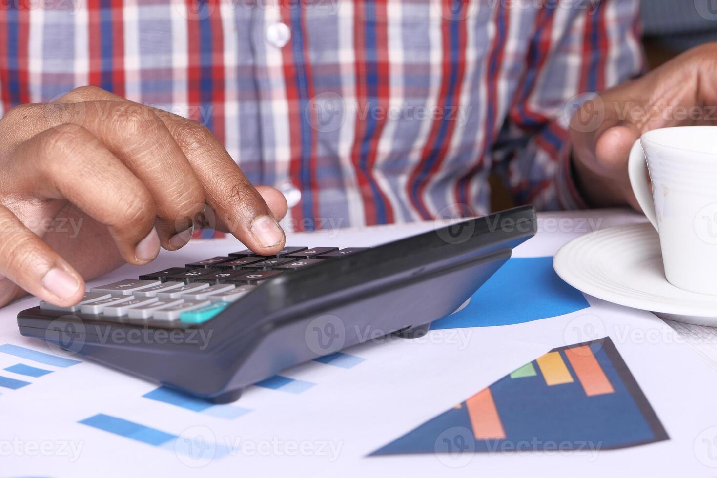 person hand using calculator on offie desk. photo