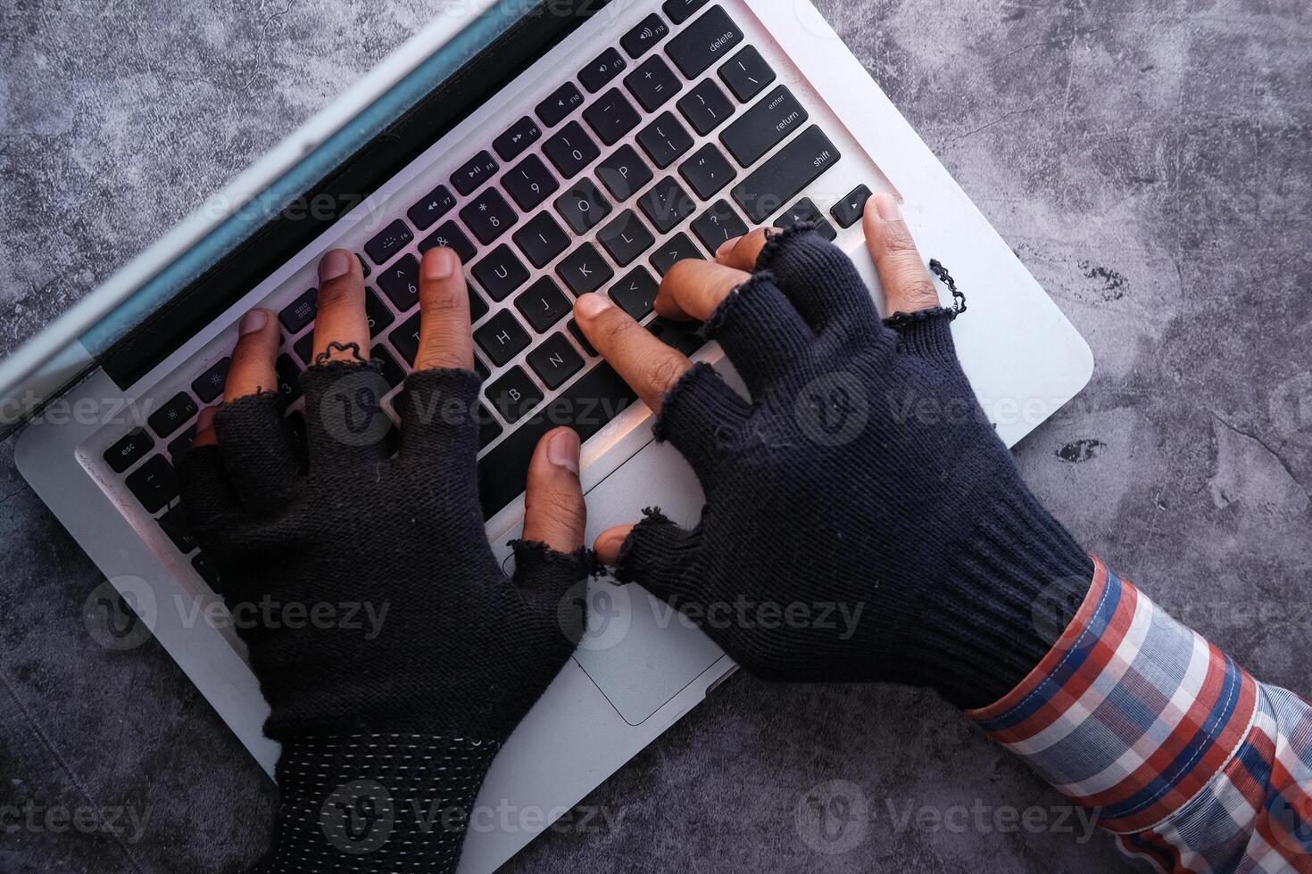 hacker hand stealing data from laptop top down photo