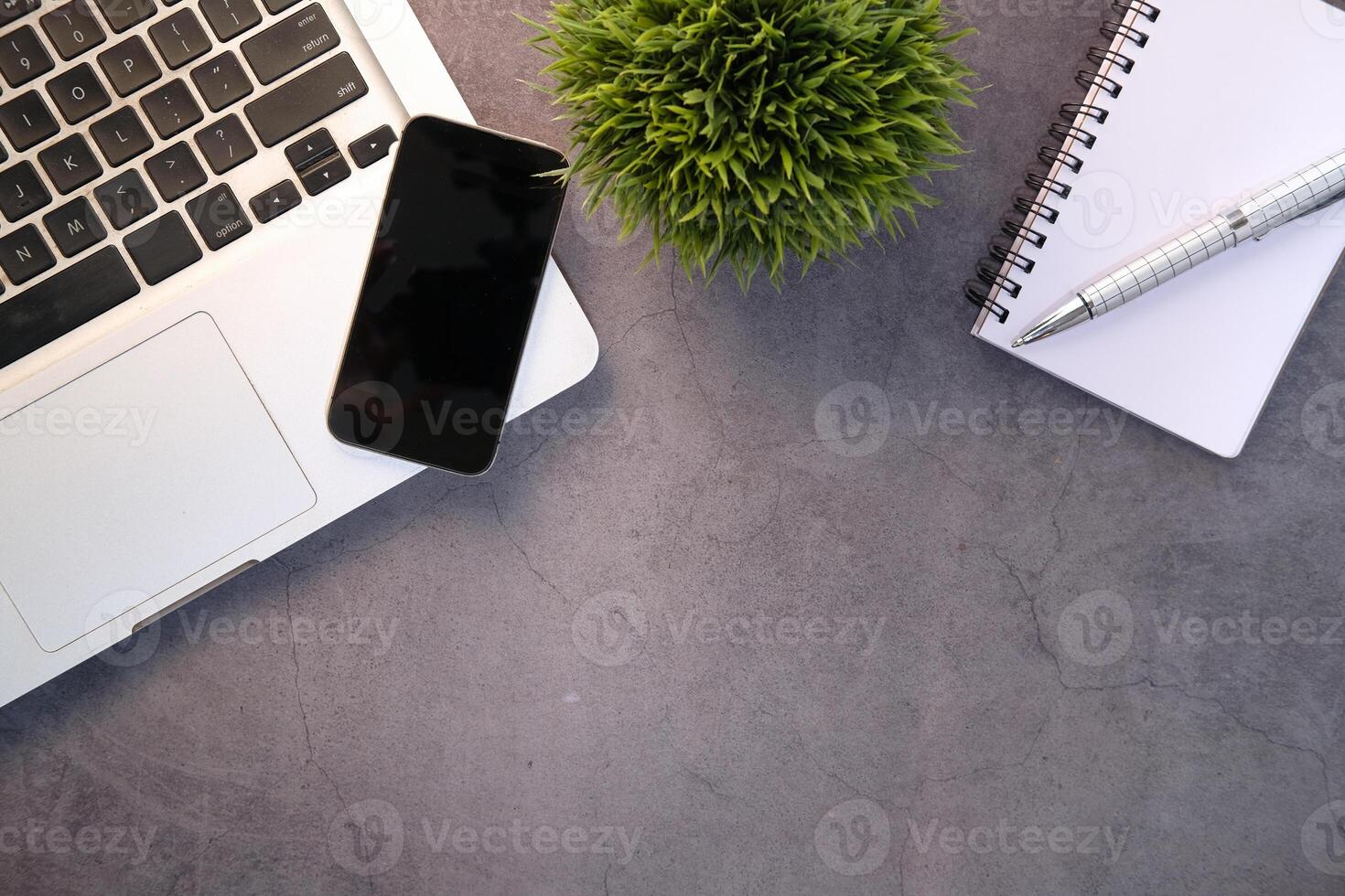 top view of smart phone, laptop and notepad on table photo