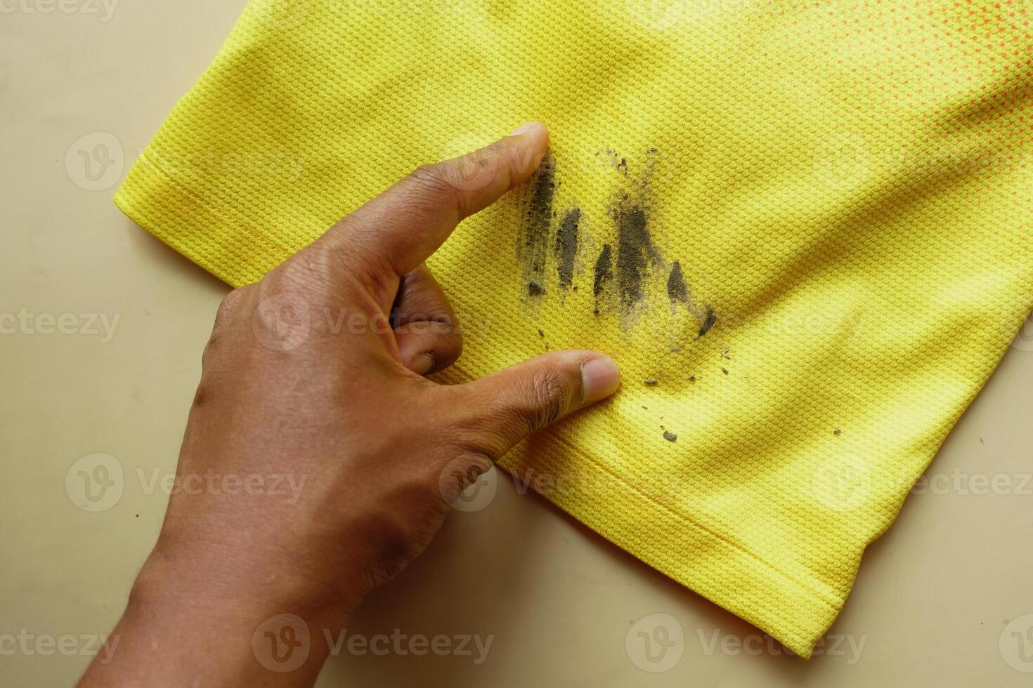 man holding dirty shirt, showing making stain photo