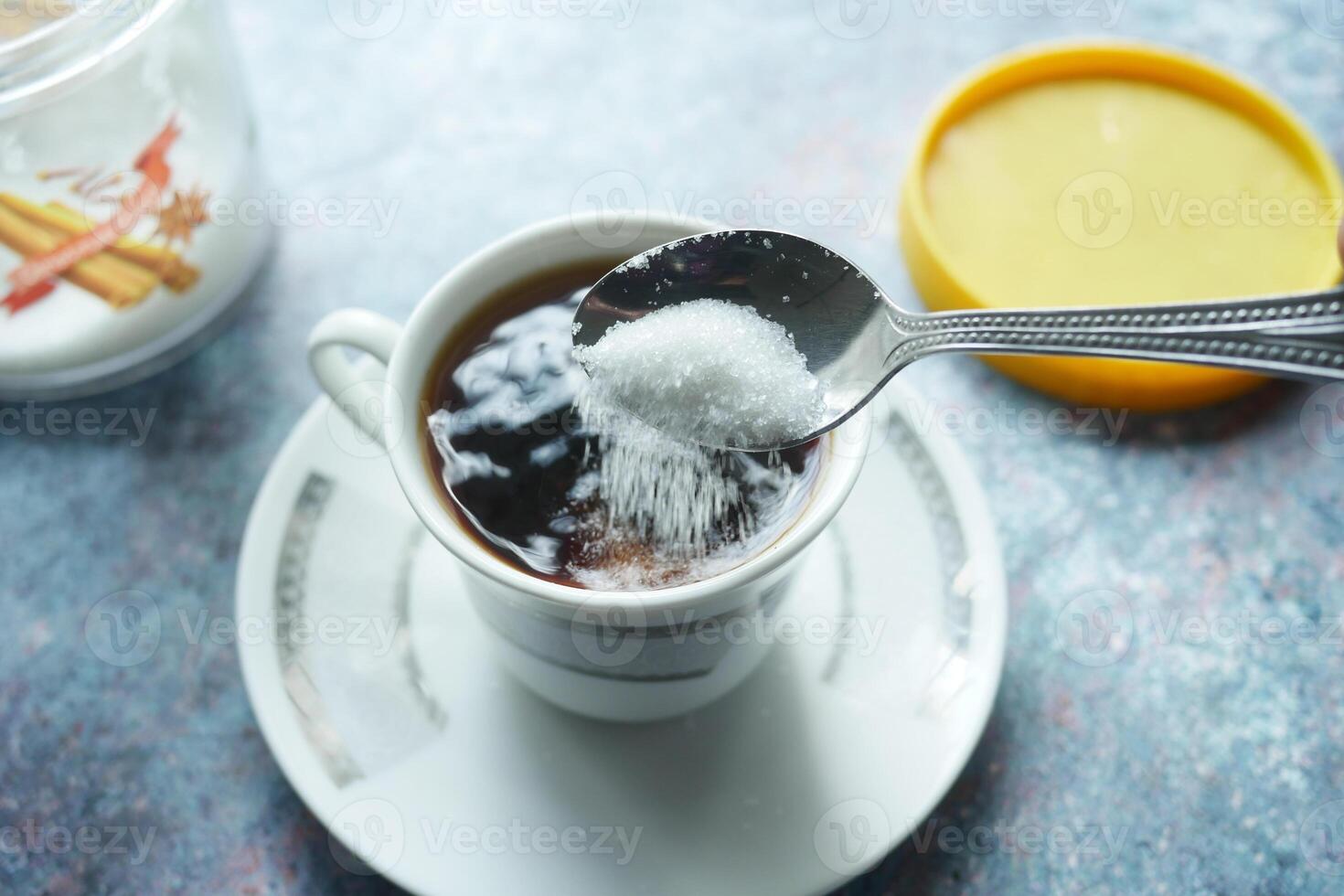 pouring white sugar in a coffee cup , photo