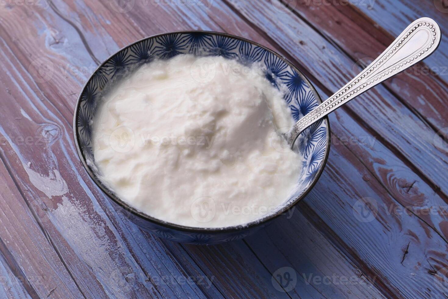 close up of fresh yogurt in a bowl on color background photo