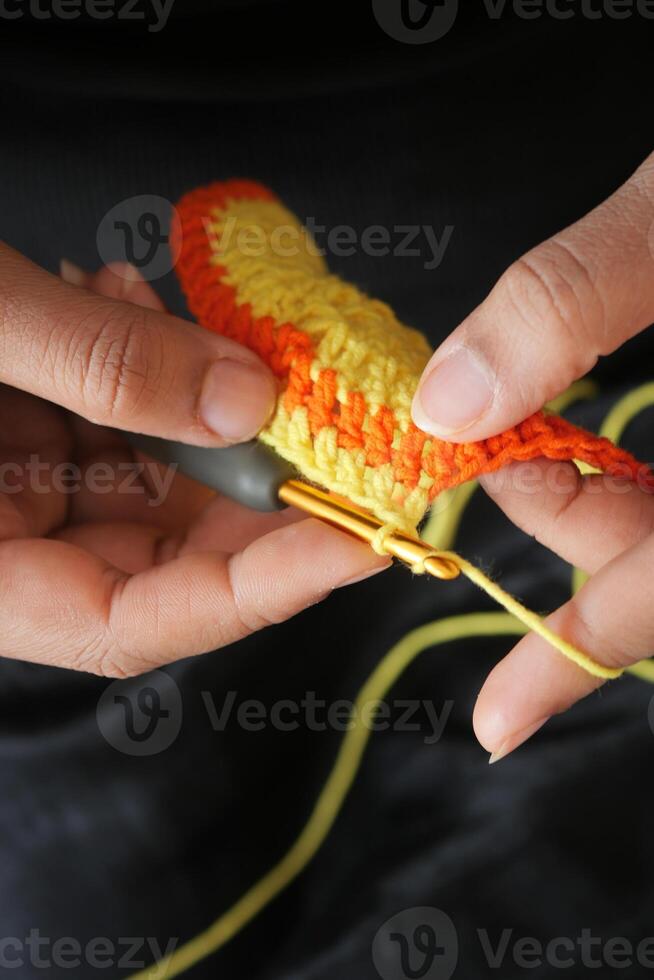 Hand close up crocheting with a hook, wool yarn, creative craft photo
