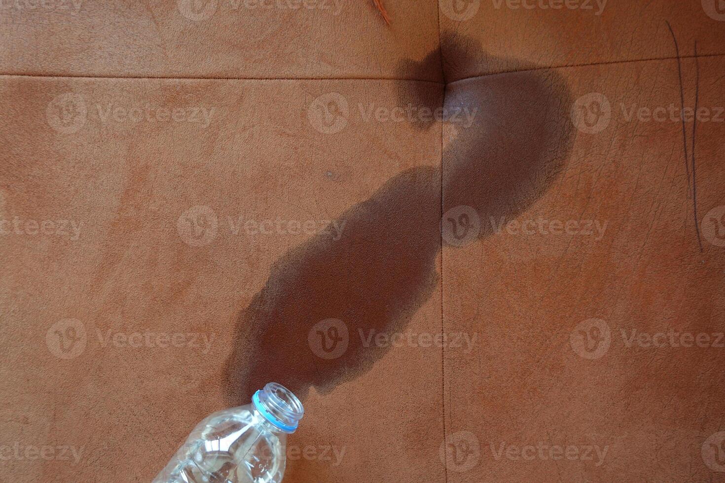 bottle of water spilled on sofa photo