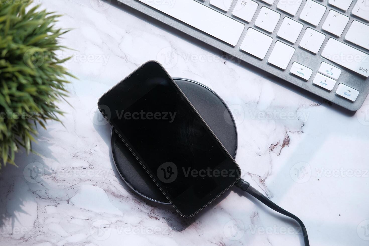 charging Smartphone Using Wireless Charging Pad, top view photo