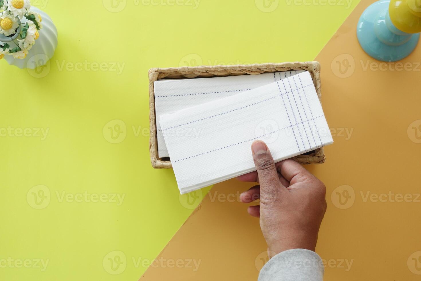 hand pull out a piece of tissue from tissue paper box photo