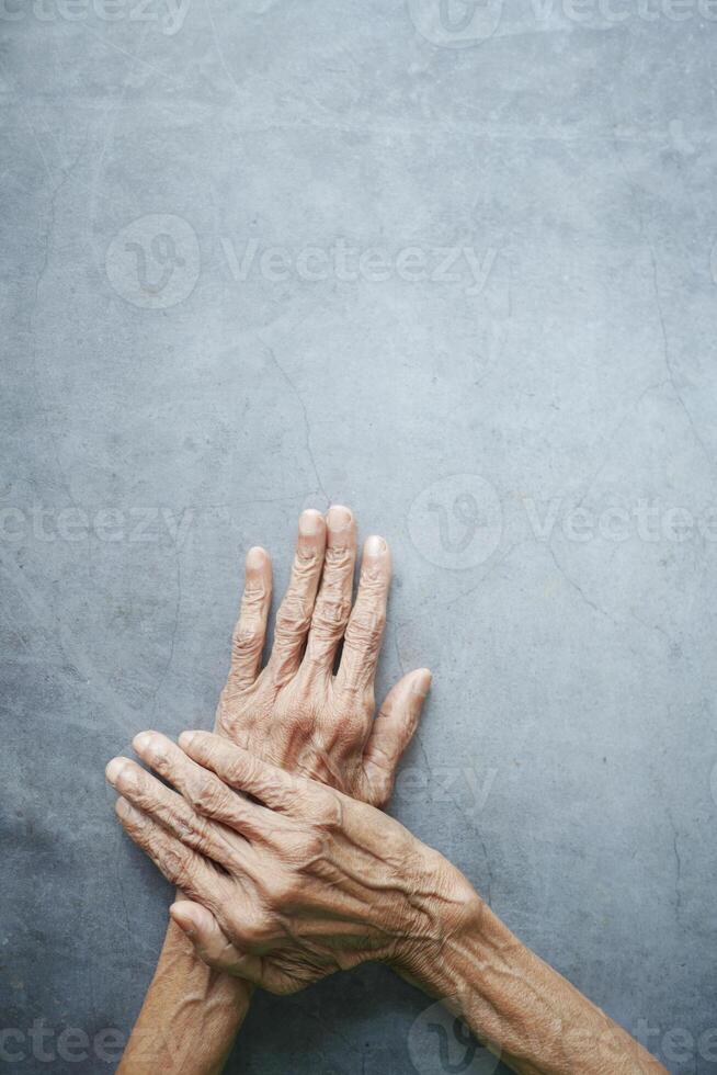top view of hands of a elderly person on black background photo