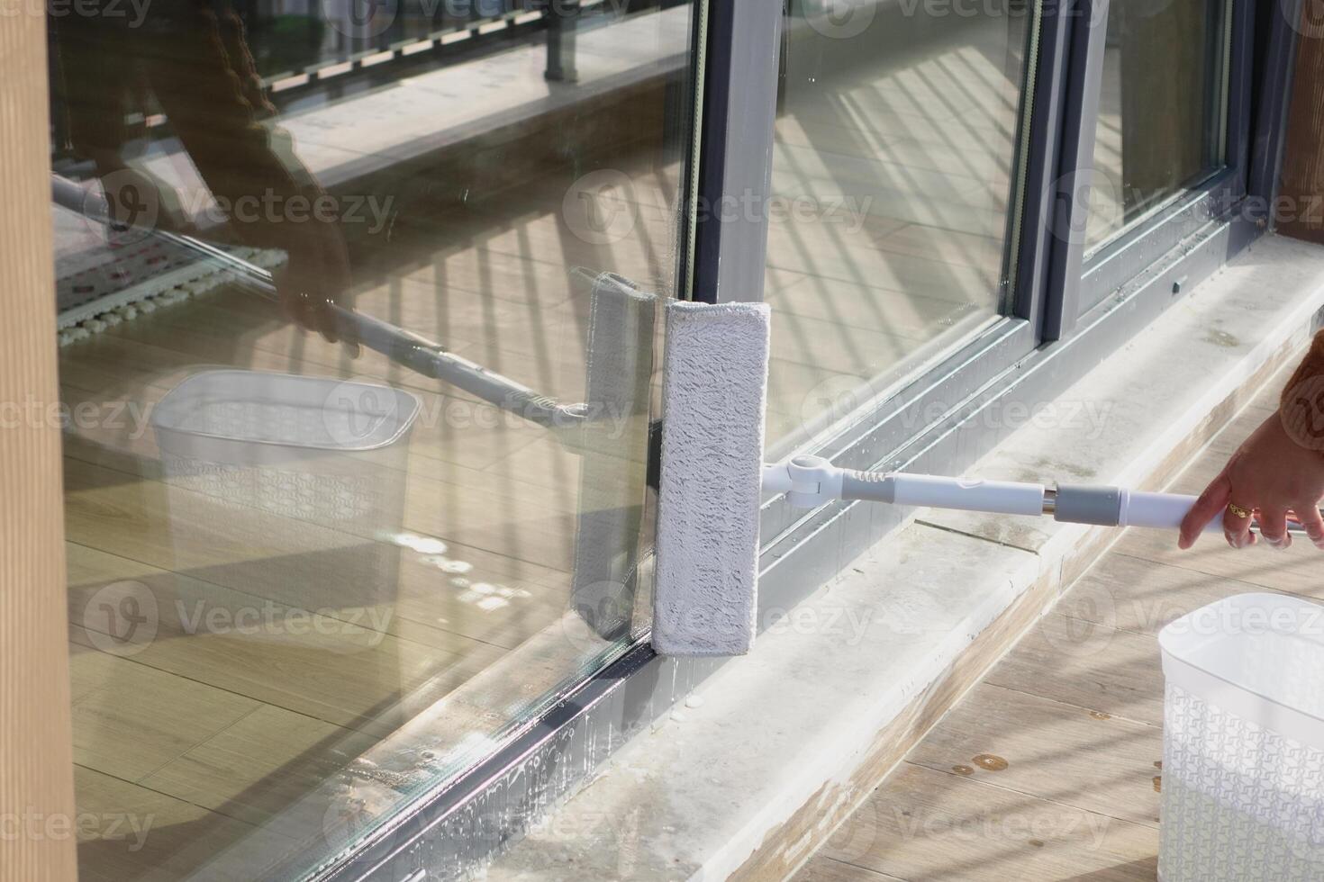 Rubber squeegee cleans a soaped window. photo