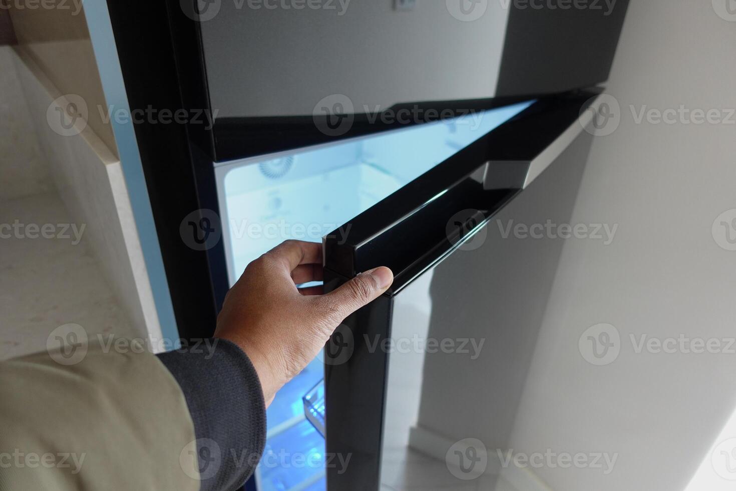 Man hand open empty fridge door photo