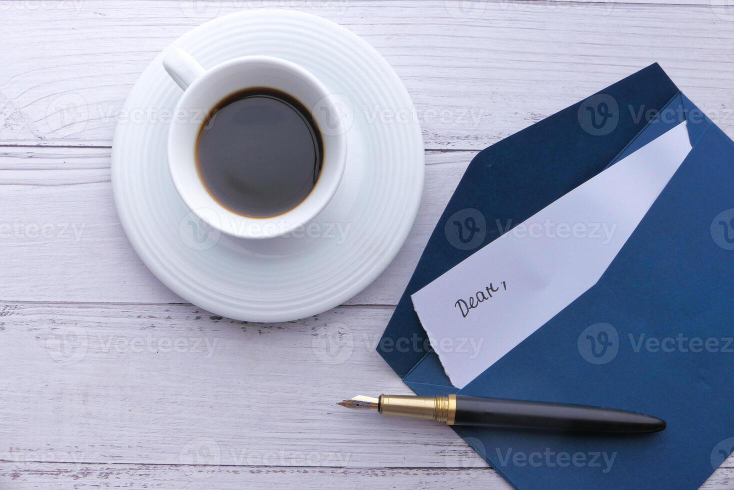 high angle view of envelope, letter and tea on table. photo