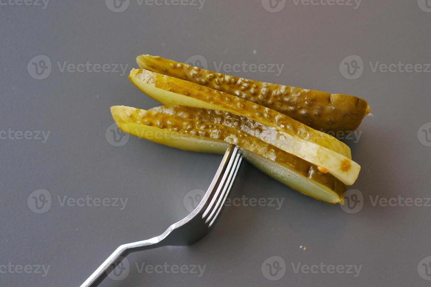 a close up of a pickle on a plate with tomatoes photo