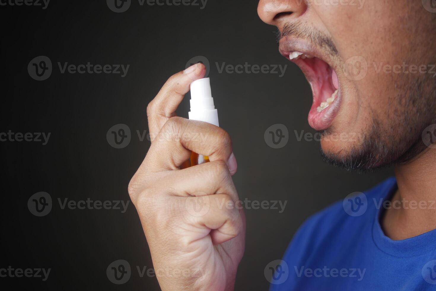 Young Man Applying Fresh Breath Spray photo