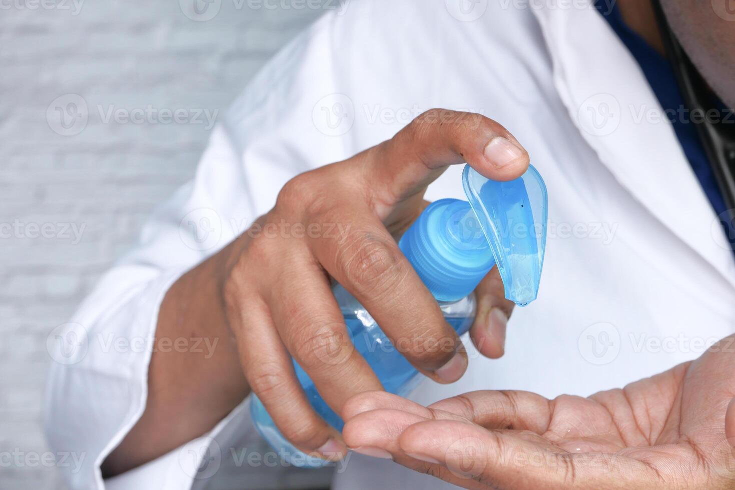 Close up of doctor hand using sanitizer for preventing virus photo