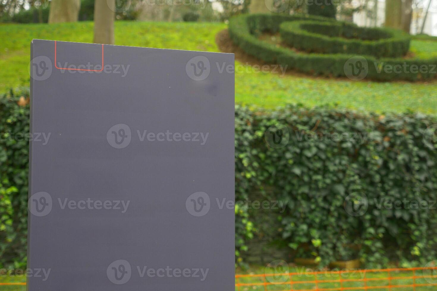 A black ciramic billboard stands in the park photo