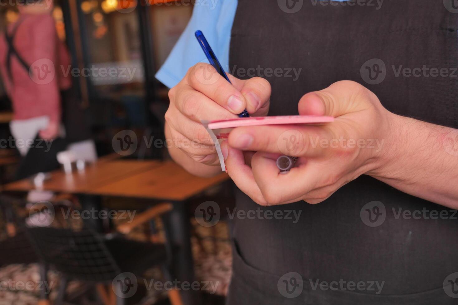 a waiter writing oder on a notebook photo