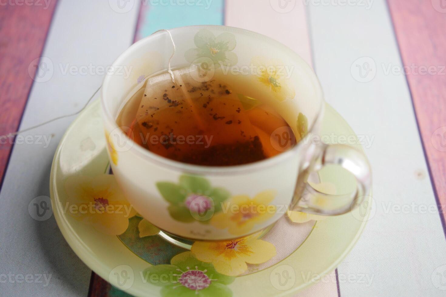 green tea and tea bag on table, close up. photo