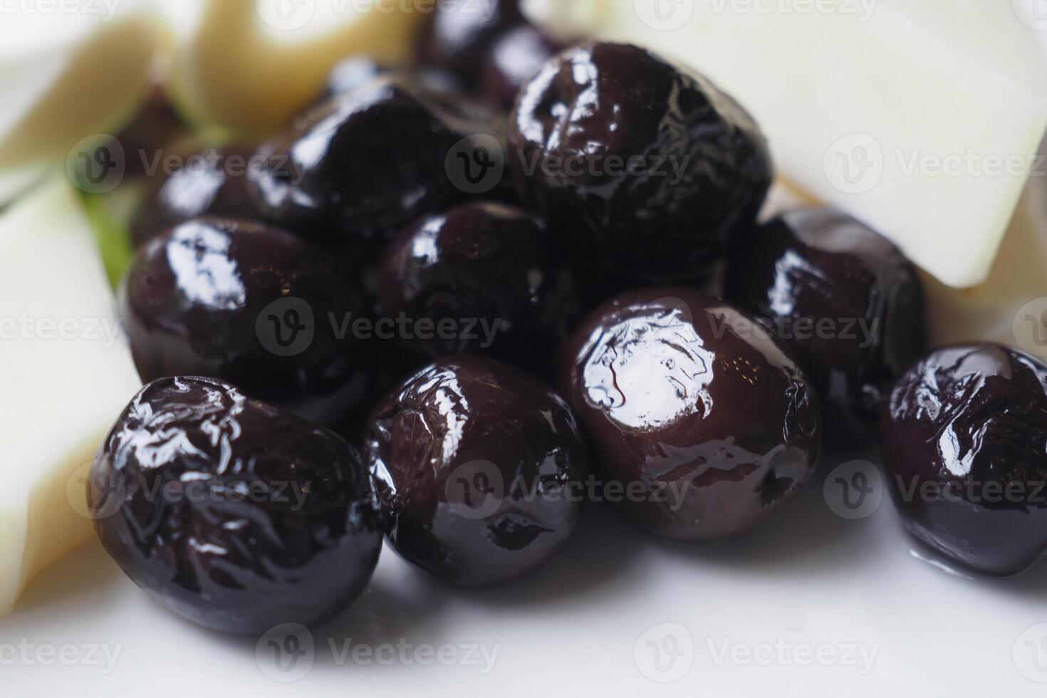 Collection of black olives with cheese on a plate . photo